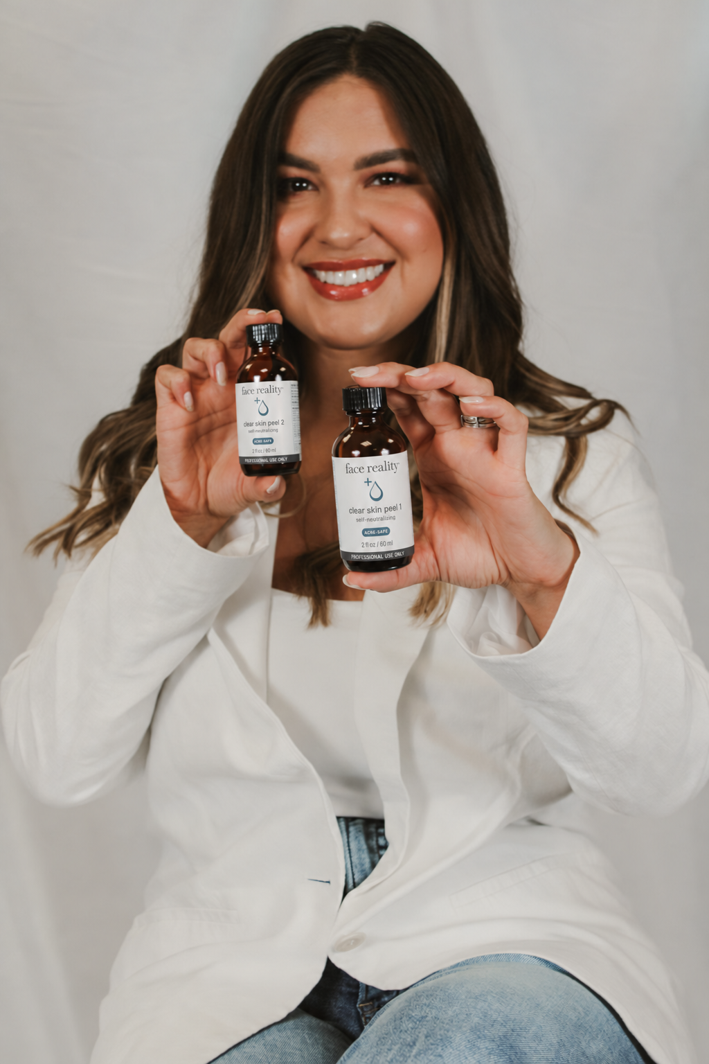 priscilla the owner of boston skincare holding face reality skincare chemical peels for acne, inflammation, breakouts and skin health