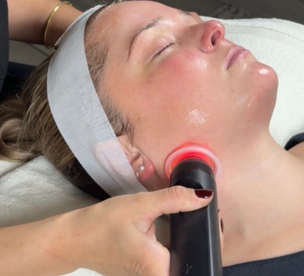Glo2Facial sculpting lymphatic massage performed along a client’s jawline