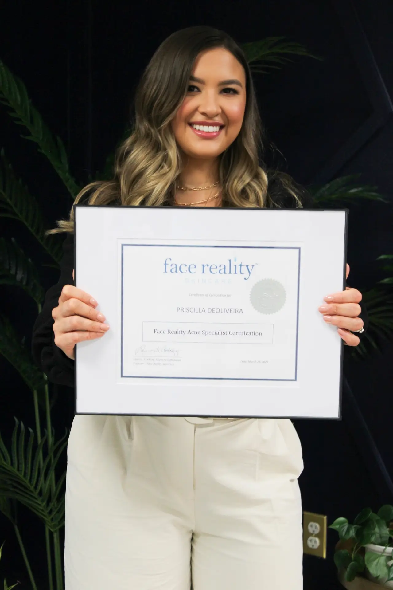 priscilla holding her acne expert face reality certification